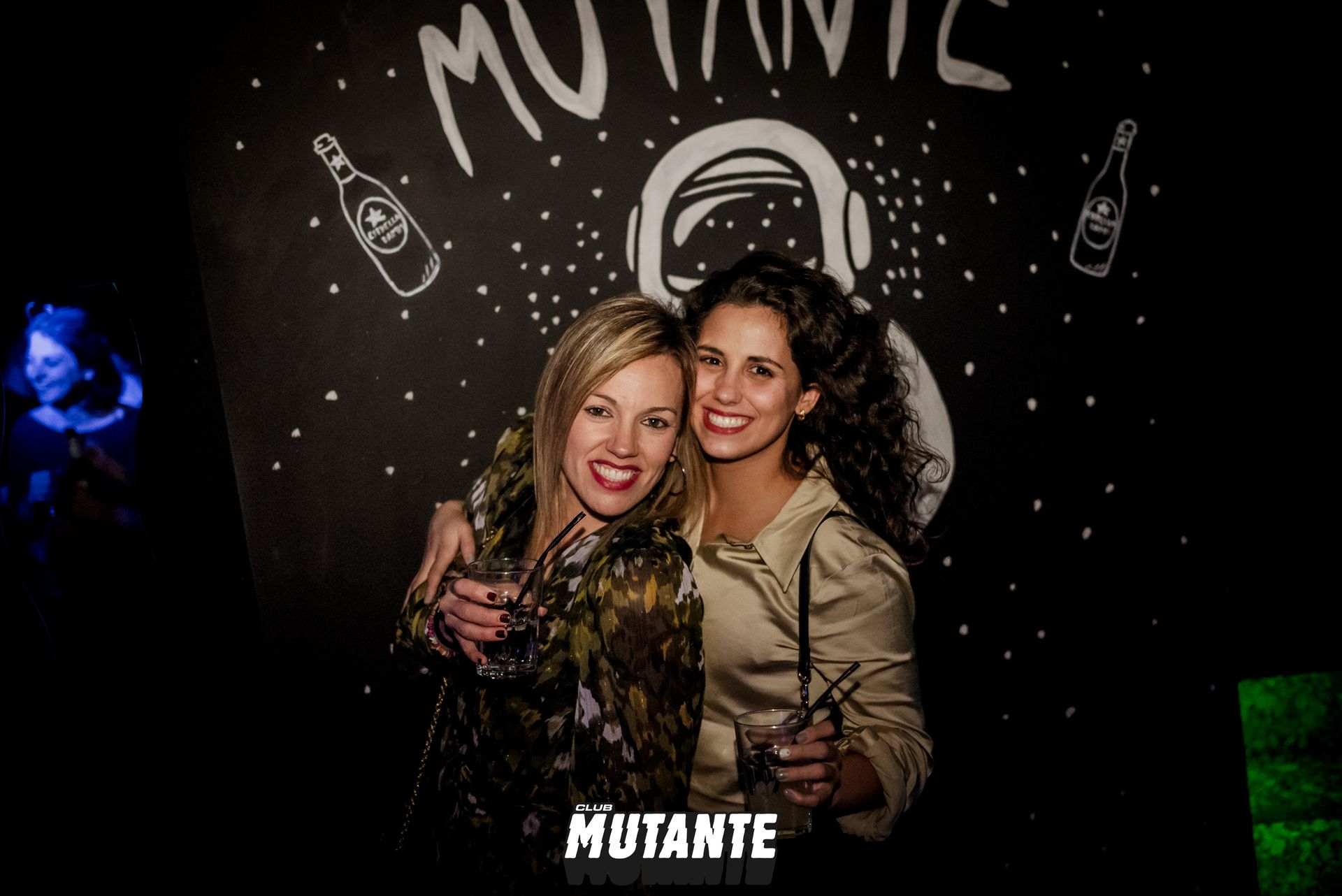 Dos mujeres posan para una fotografía delante de una pizarra.