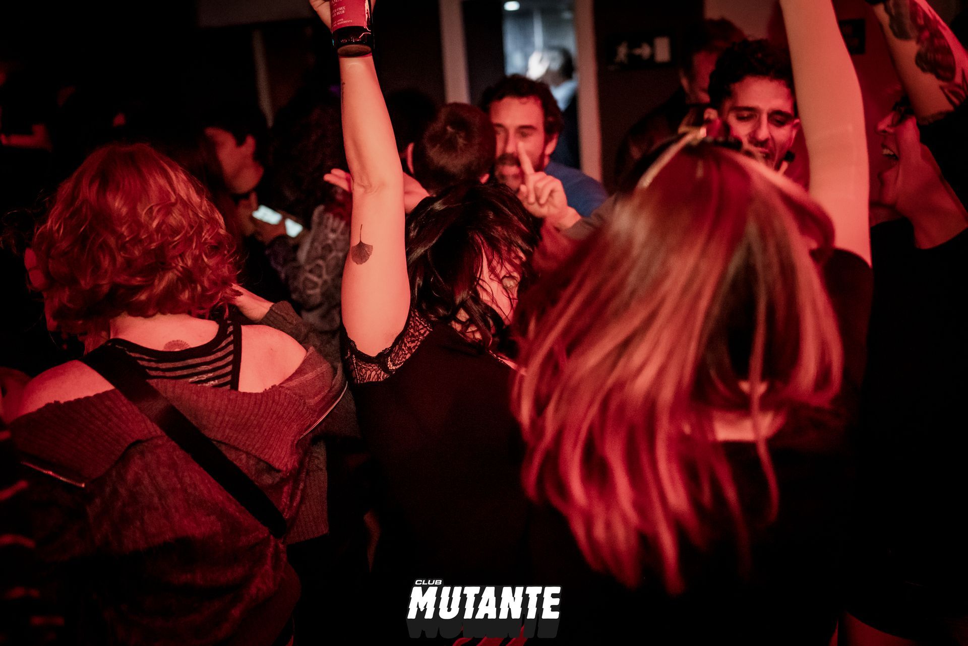 Un grupo de personas está bailando en una fiesta con la palabra mutante de fondo.