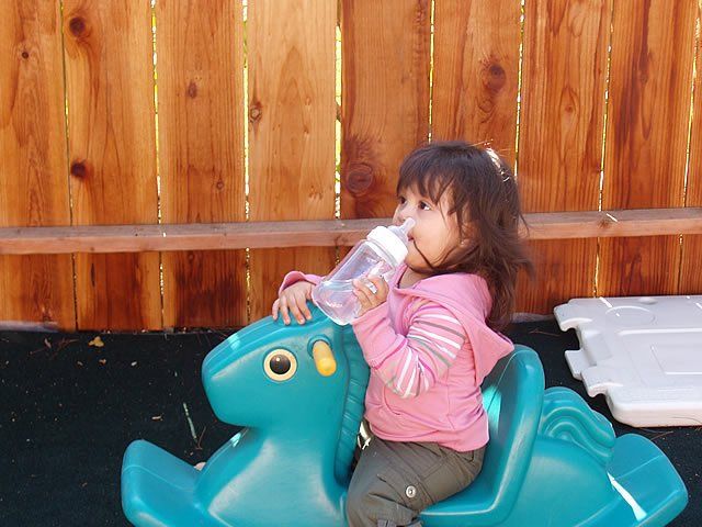 Little girl playing while holding bottle - My Second Home - Concord, CA