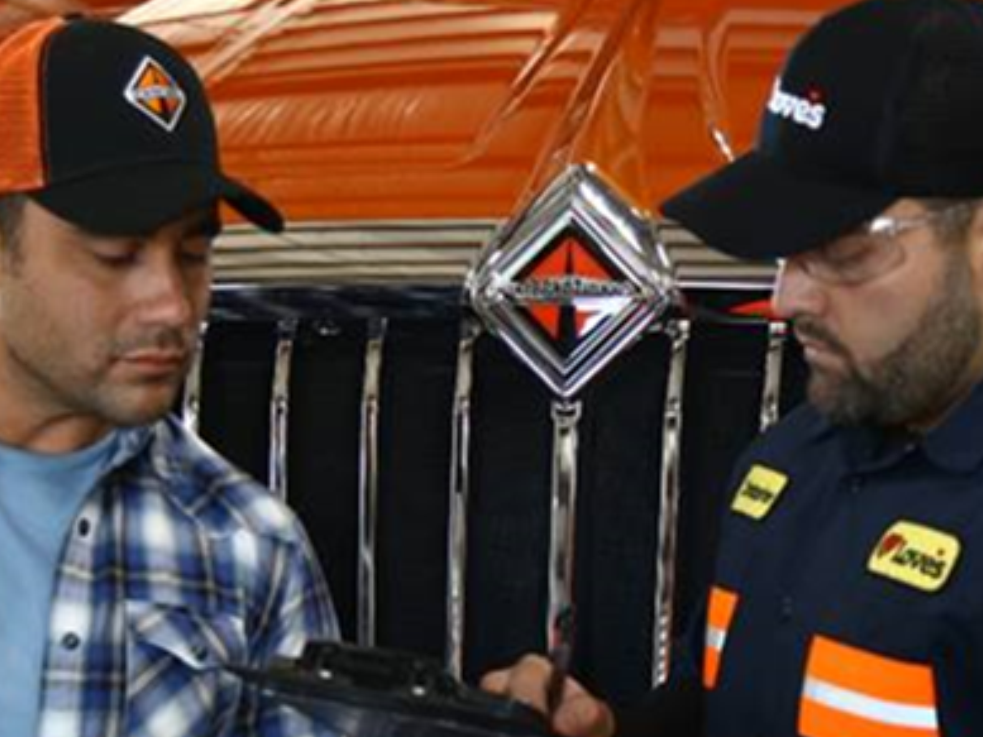 Two men standing in front of an international truck