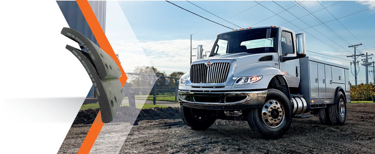 A white truck is parked in a dirt field next to power lines.