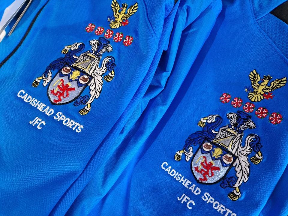 Two blue cadshead sports jfc sweatshirts are stacked on top of each other