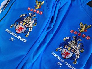 Two blue cadshead sports jfc sweatshirts are stacked on top of each other