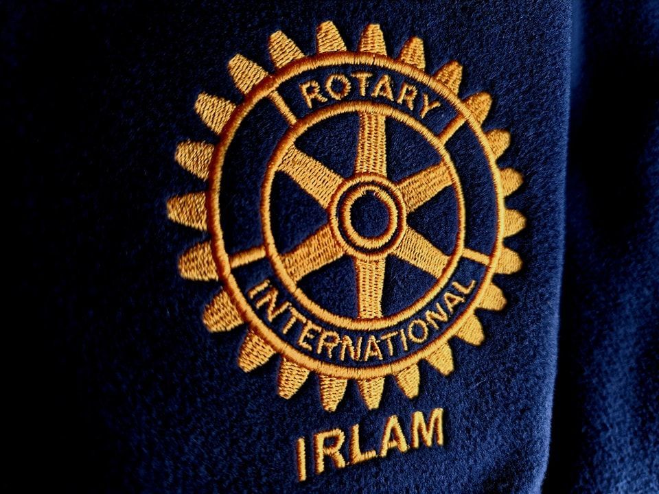 A close up of a rotary international logo on a blue shirt