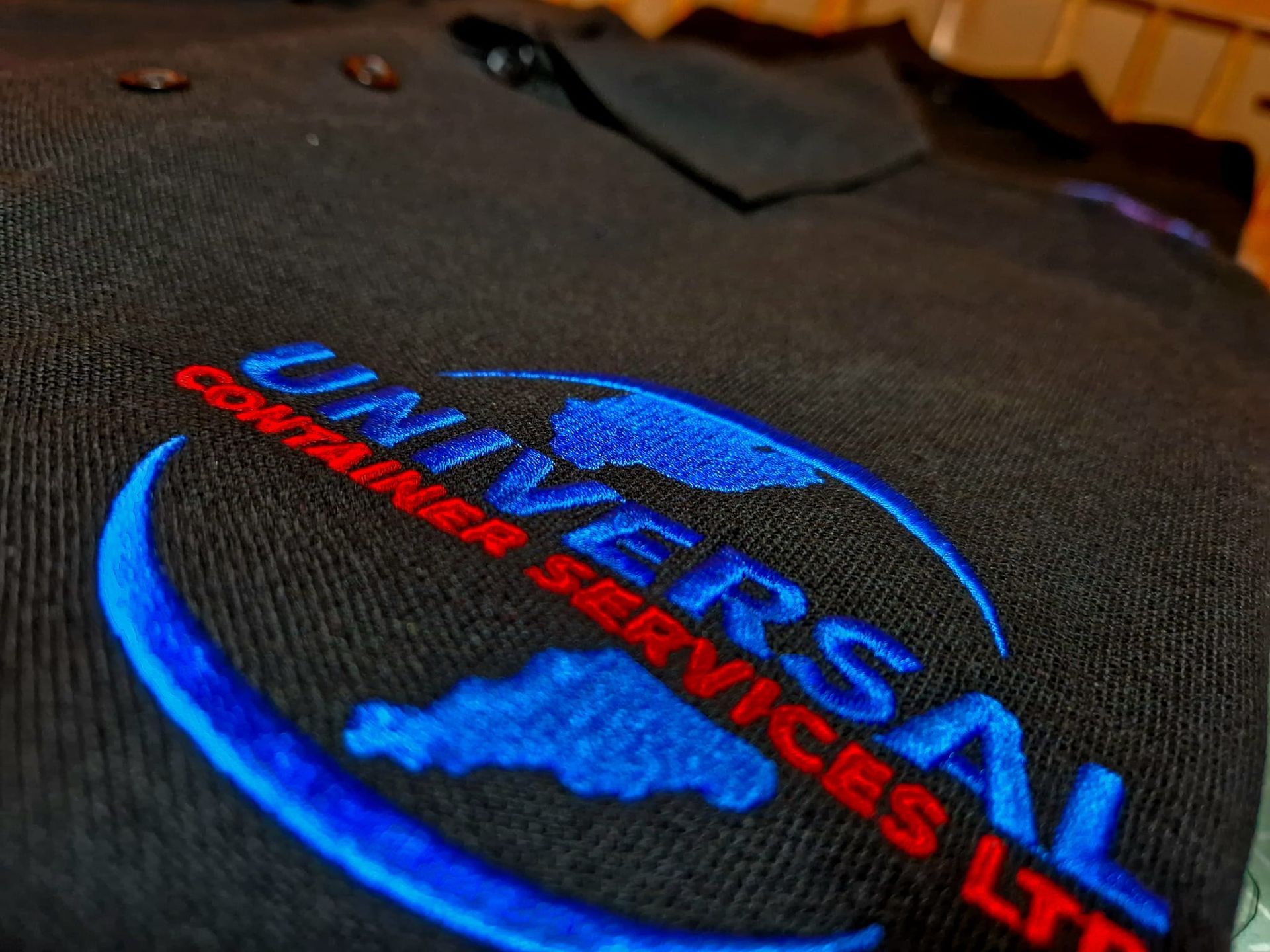 A black shirt with universal container services embroidered on it