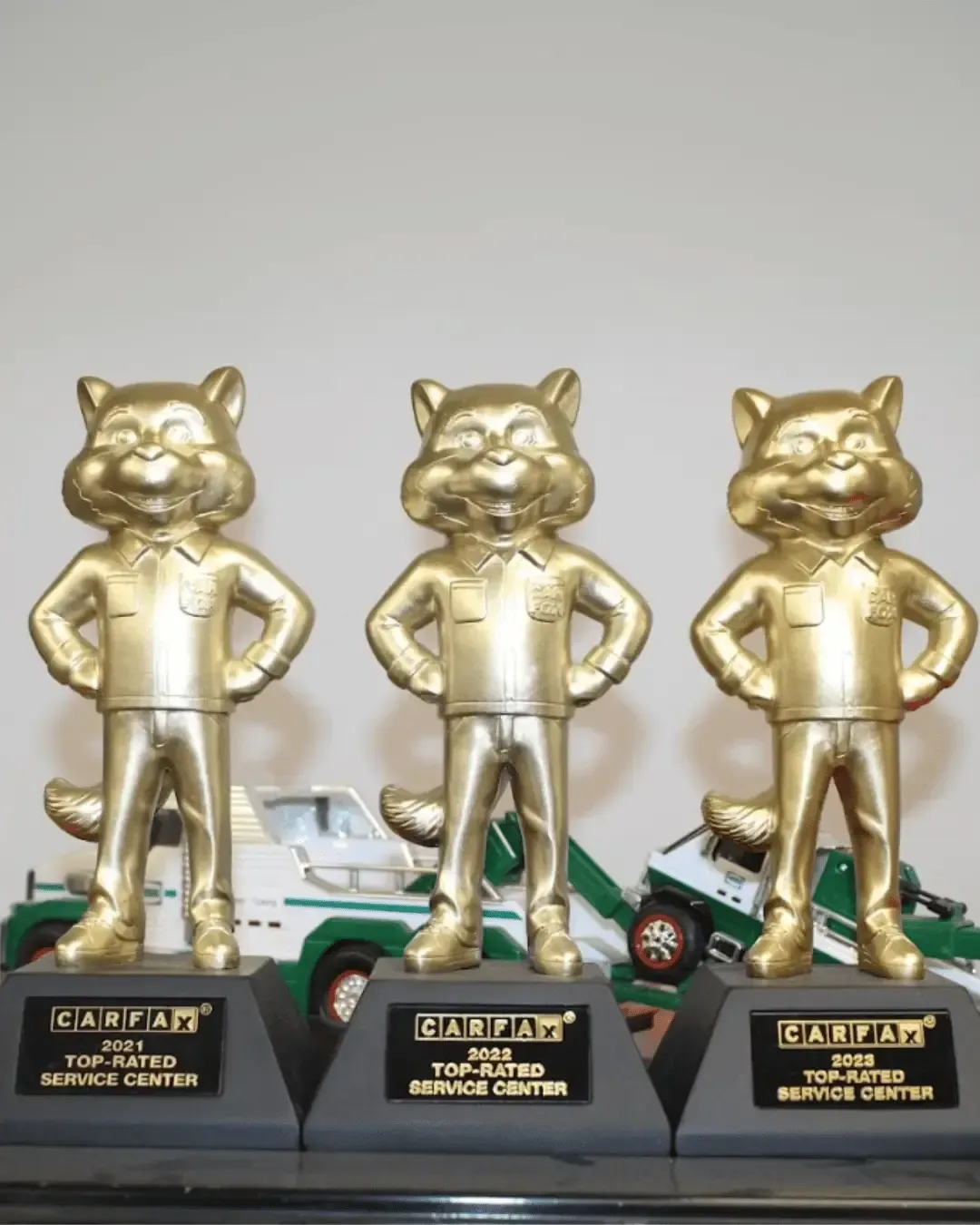 Three gold cat trophies, each on a black base, for automotive service awards. | Smithwest Service Center