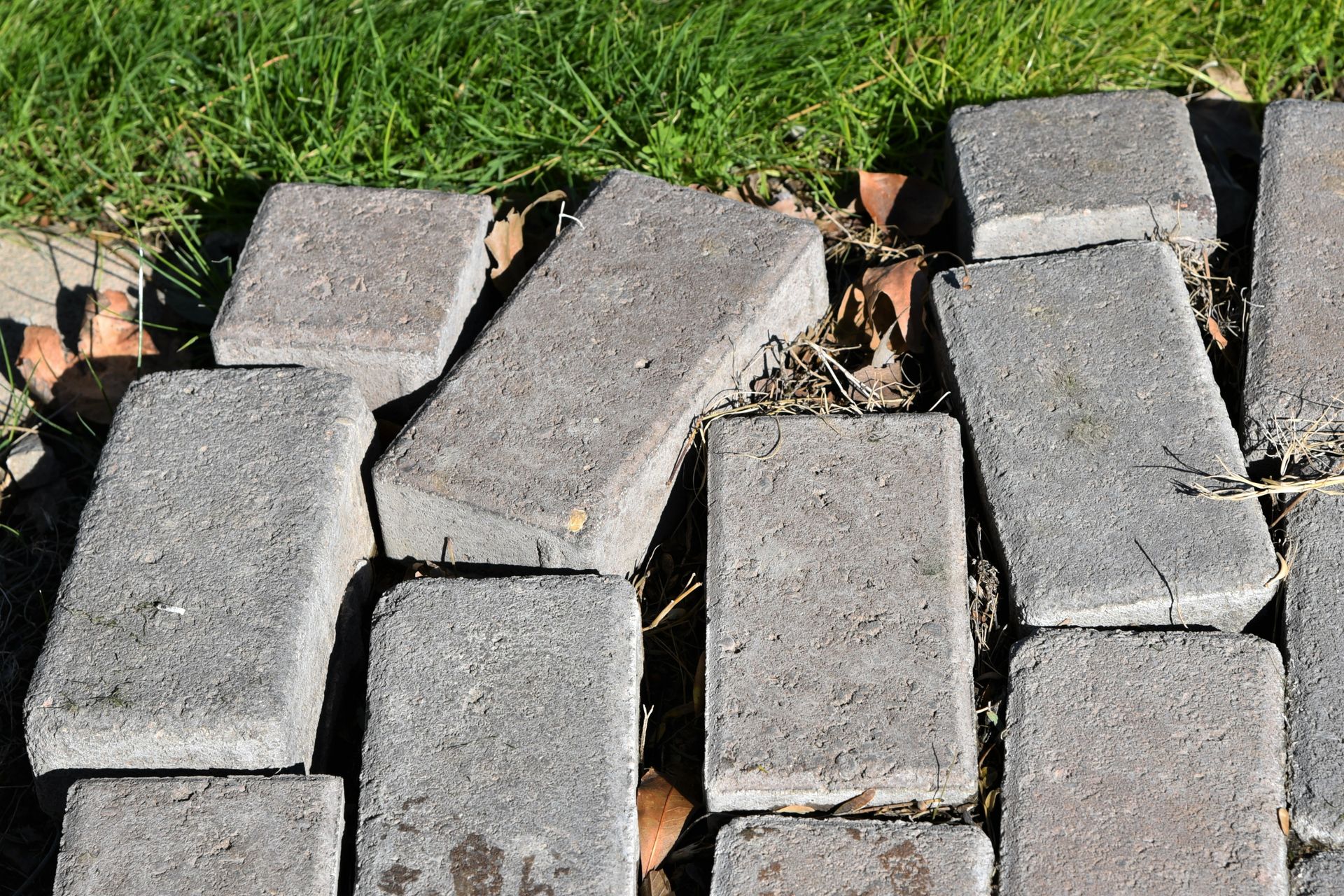 A pile of bricks laying on top of each other on a sidewalk.