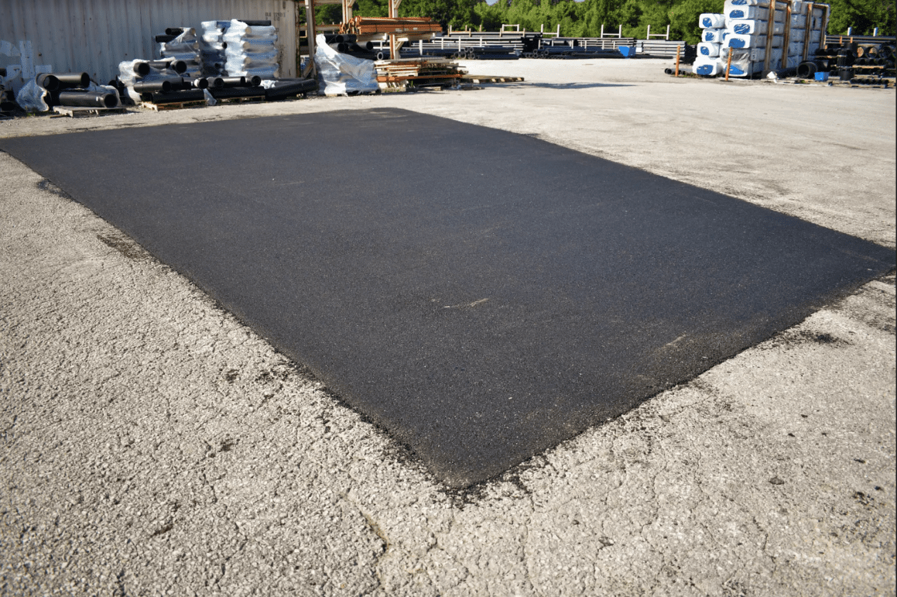 A large piece of asphalt is sitting on the ground in a parking lot.