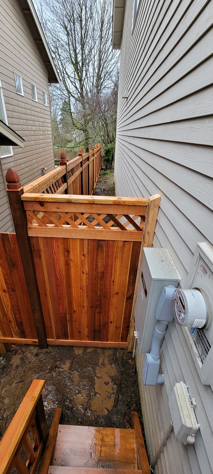 Wooden fence between two houses; stairs leading down.