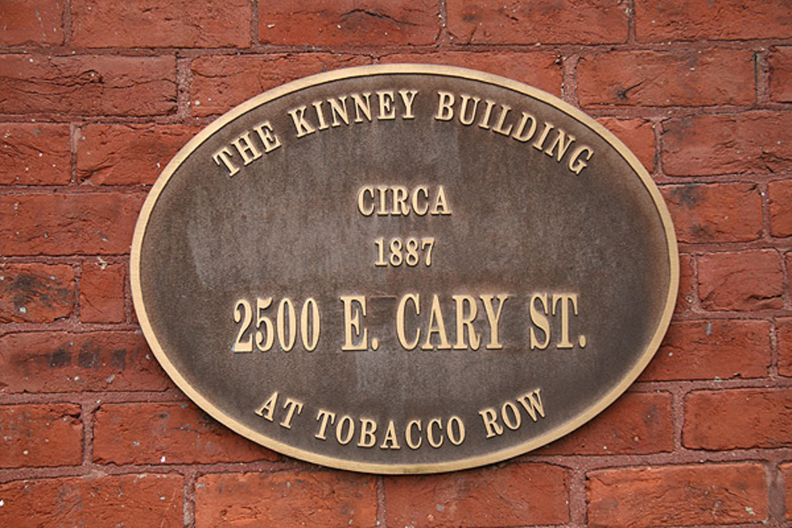 A plaque on a brick wall says the kinney building circa 1887.