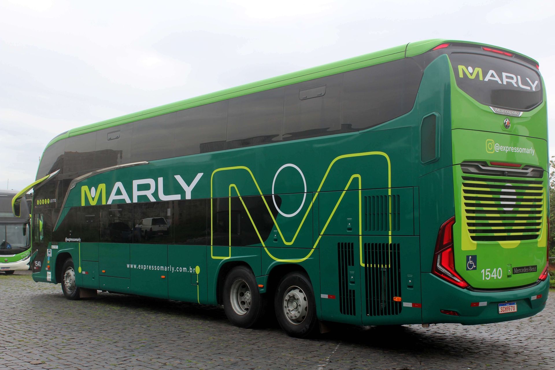 Ônibus de dois andares verde e branco com o logotipo "MARLY" estacionado ao ar livre.