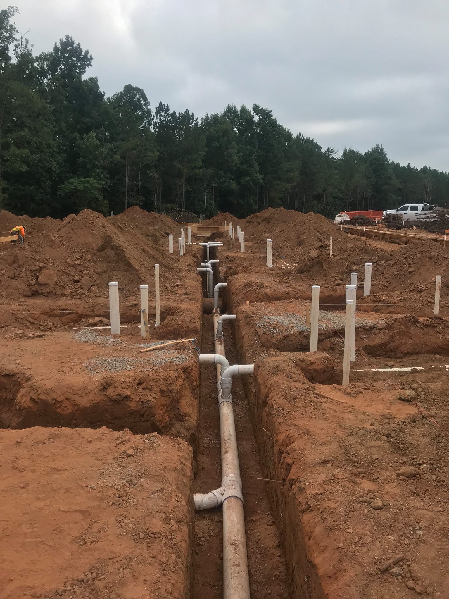 a construction site with a lot of pipes in the dirt