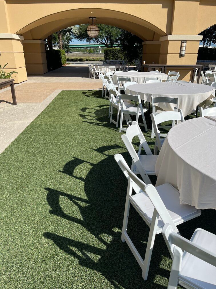 wedding chairs set up on fake green grass at a commercial venue