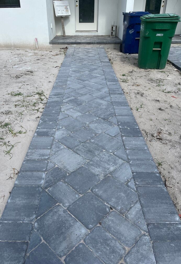 paver walkway leading to small porch with pavers at new townhouse before sod is laid