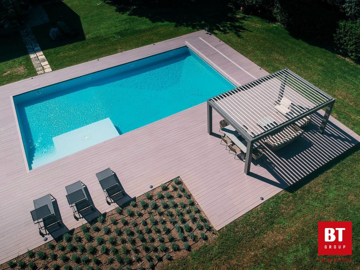 Una vista aerea di una piscina con pergolato e sedie