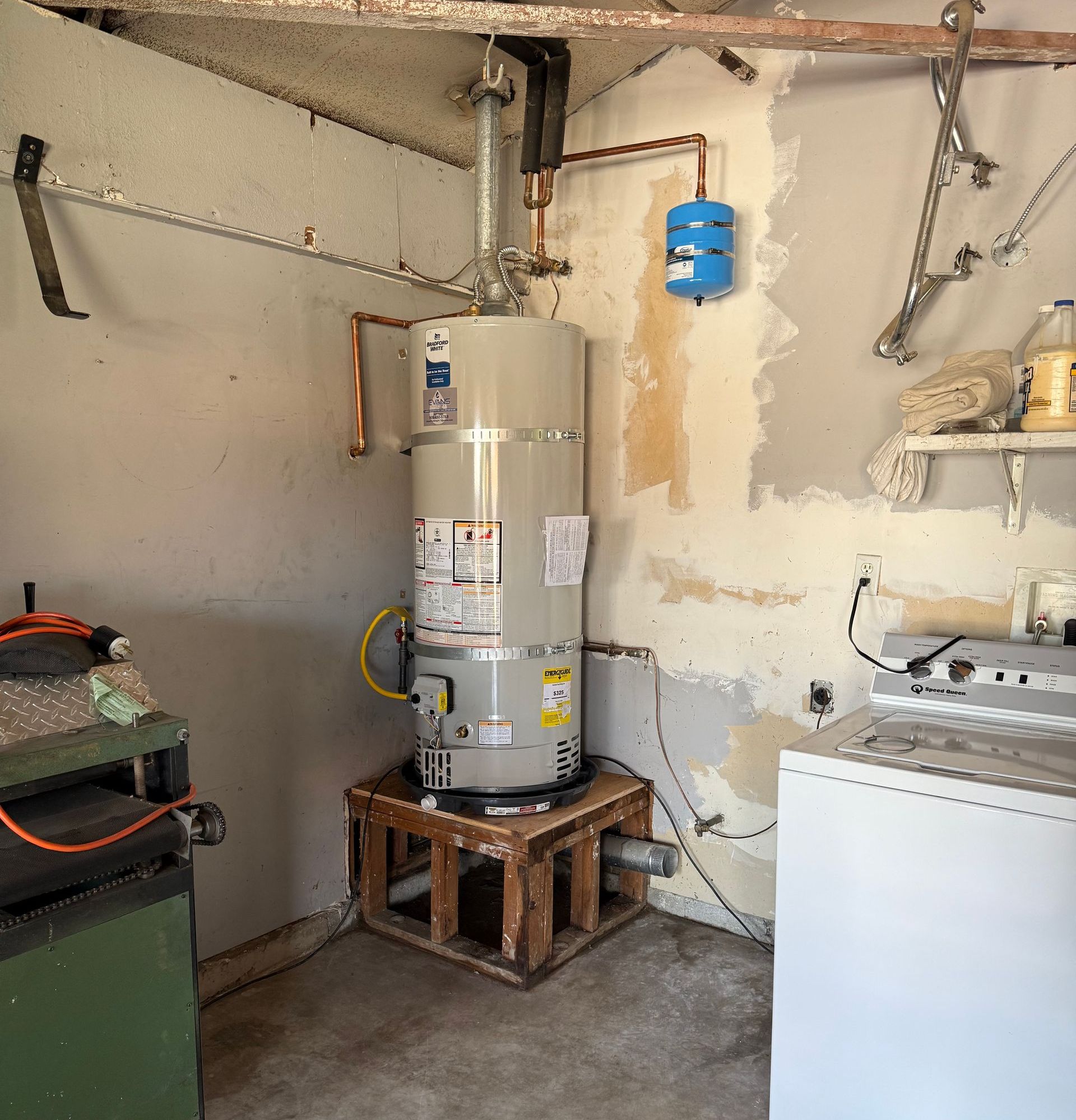 A room with a water heater and a washer and dryer