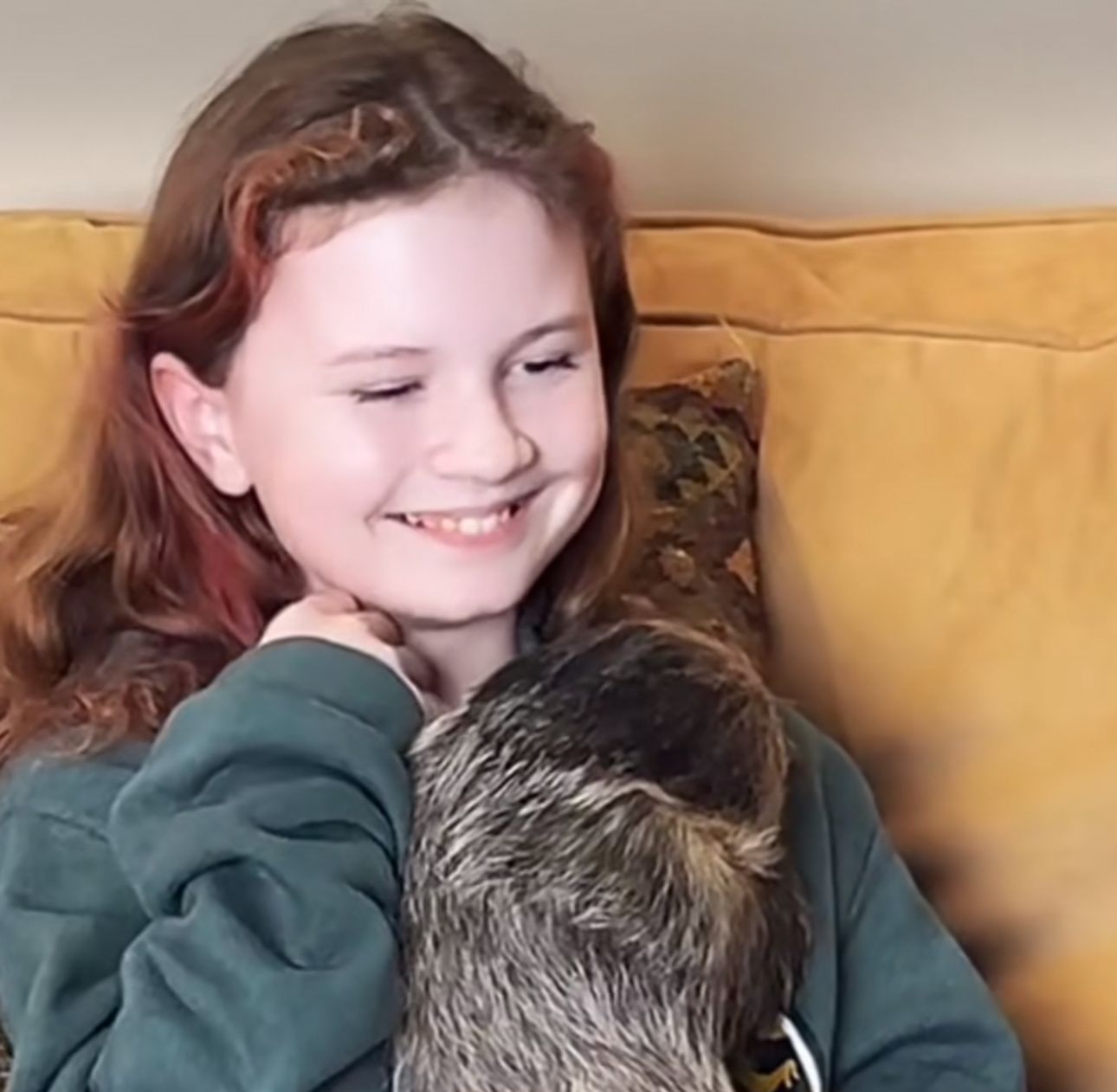 A young girl is holding a cat and smiling