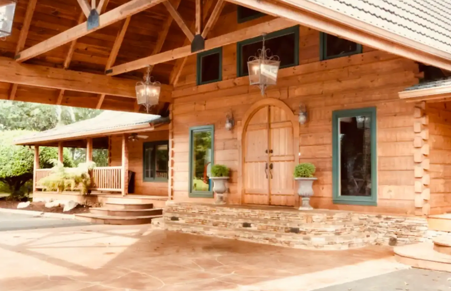 A large wooden house with a porch and a large wooden door.