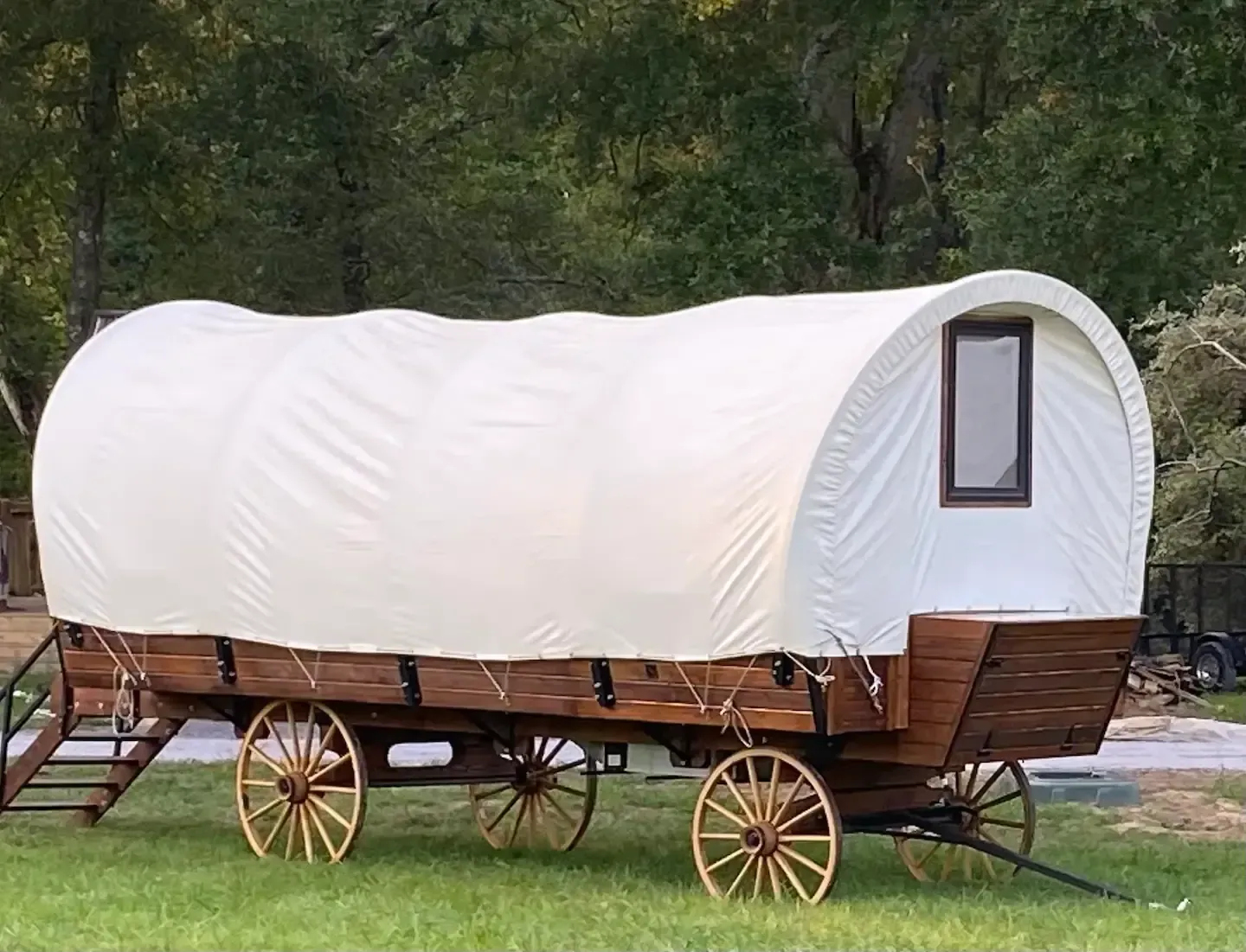 A covered wagon is parked in a grassy field.