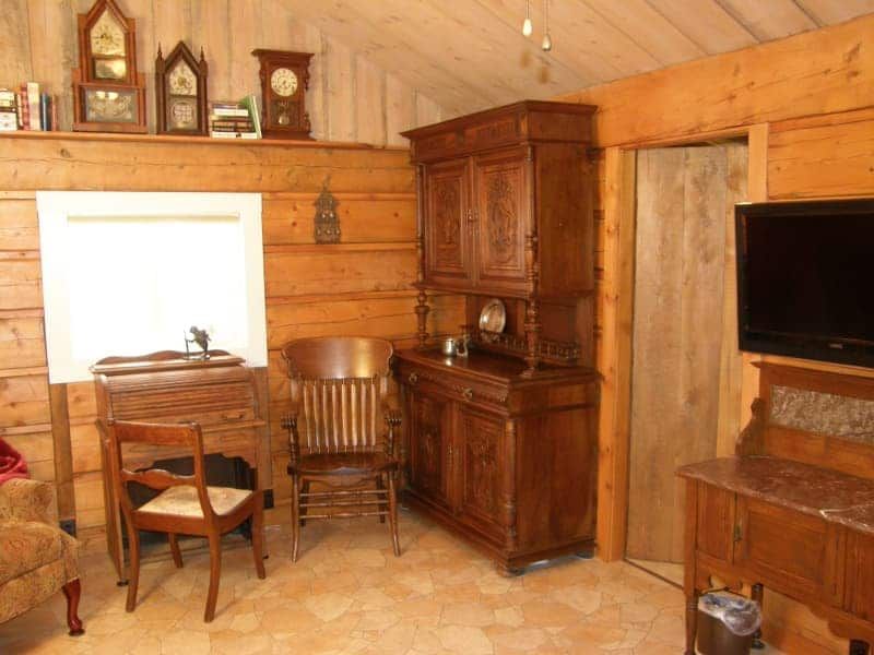 A living room with wooden furniture and clocks on the wall