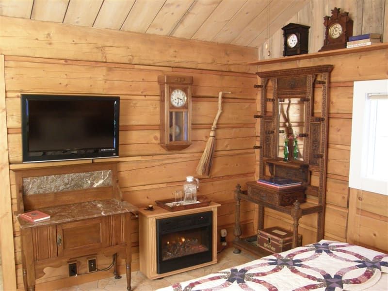 A bedroom with a fireplace and a flat screen tv
