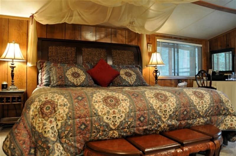 A bedroom with a canopy bed and lamps