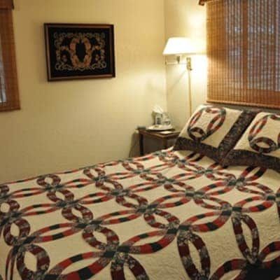 A bedroom with a bed and a picture on the wall above it.