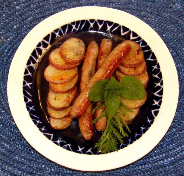 A plate of sausages and potatoes on a table