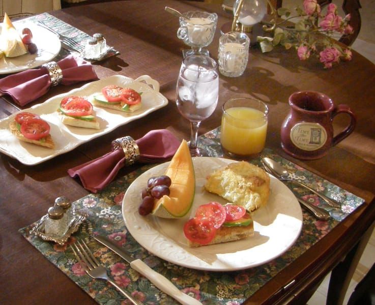 A table with plates of food and a mug that says ' a ' on it