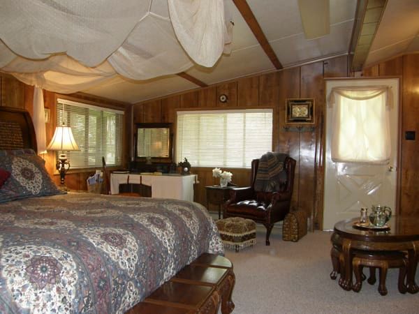 A bedroom with a canopy bed and a chair