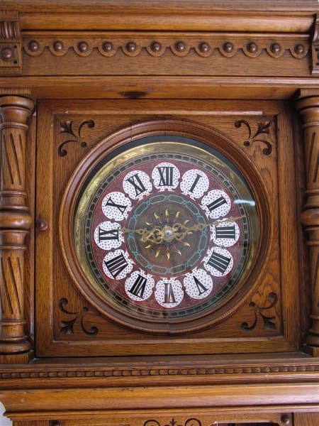 A wooden clock with roman numerals on the face