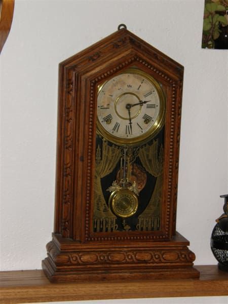 A wooden clock with roman numerals on the face