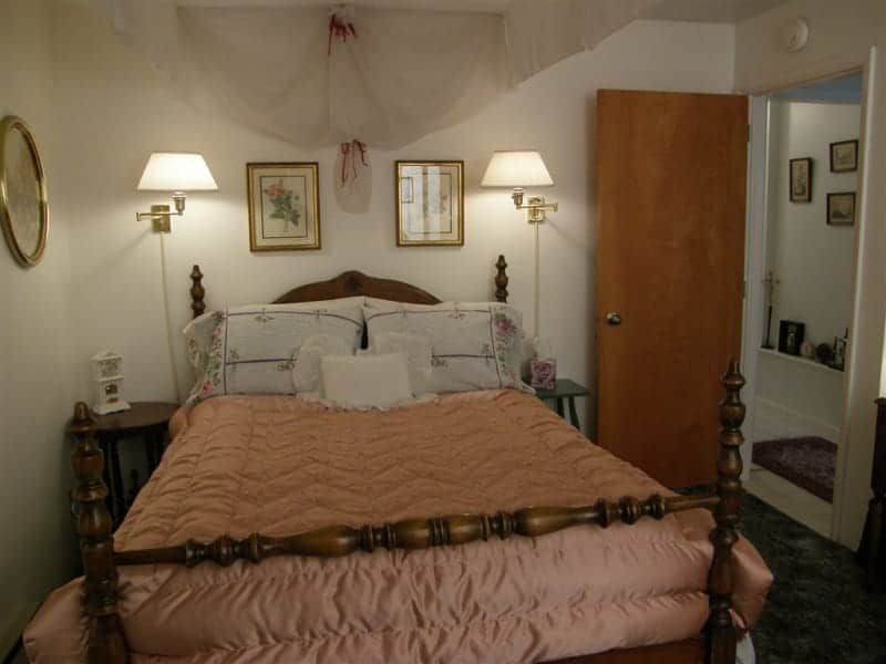 A bedroom with a canopy bed and two lamps