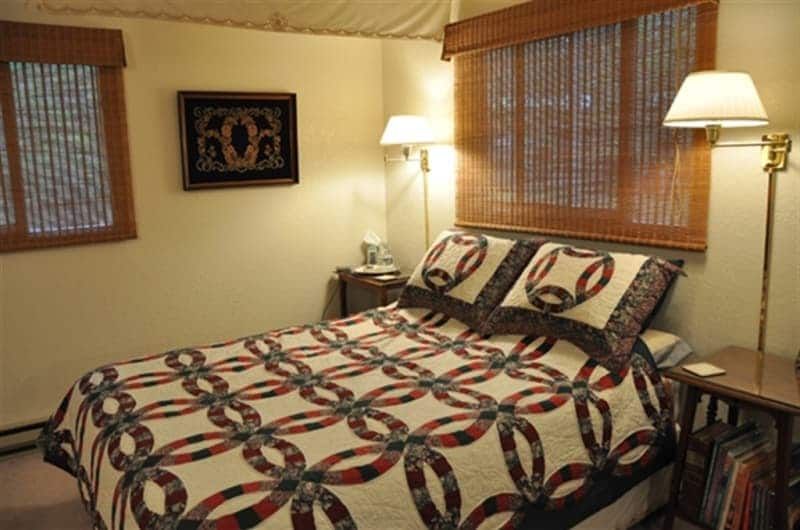 A bed with a quilt on it in a bedroom