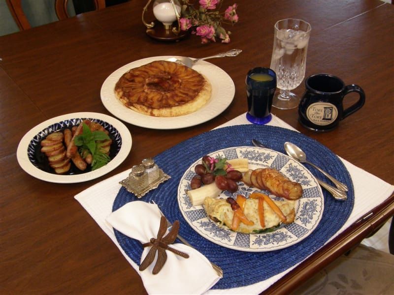 A table with plates of food and a mug with the letter d on it