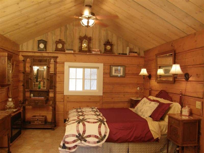 A bedroom with a bed and clocks on the wall