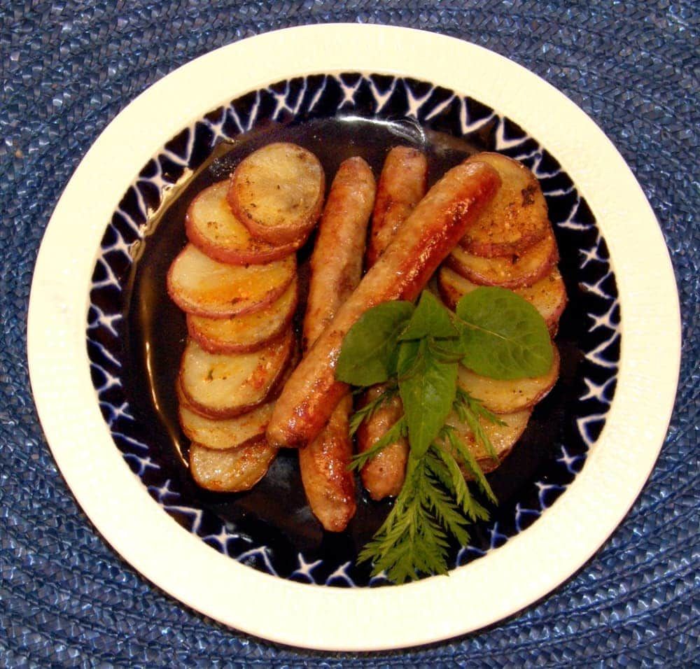 A plate of sausages and potatoes on a table