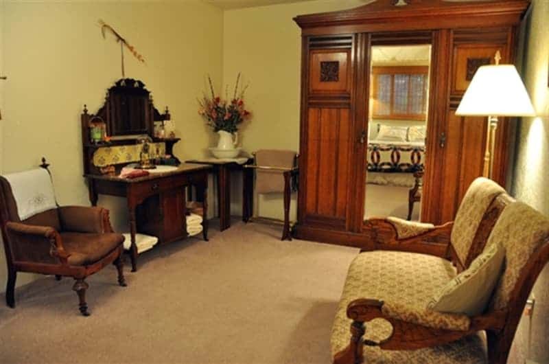 A living room with a couch a desk and a wardrobe