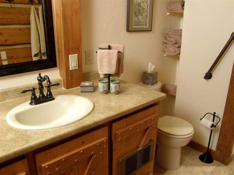 A bathroom with a sink toilet and mirror