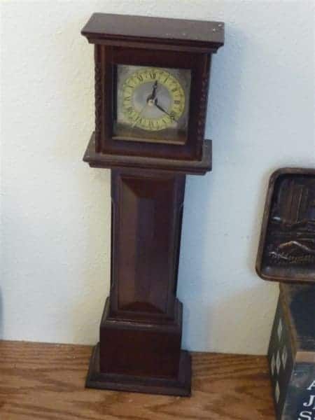 A wooden grandfather clock with roman numerals on the face