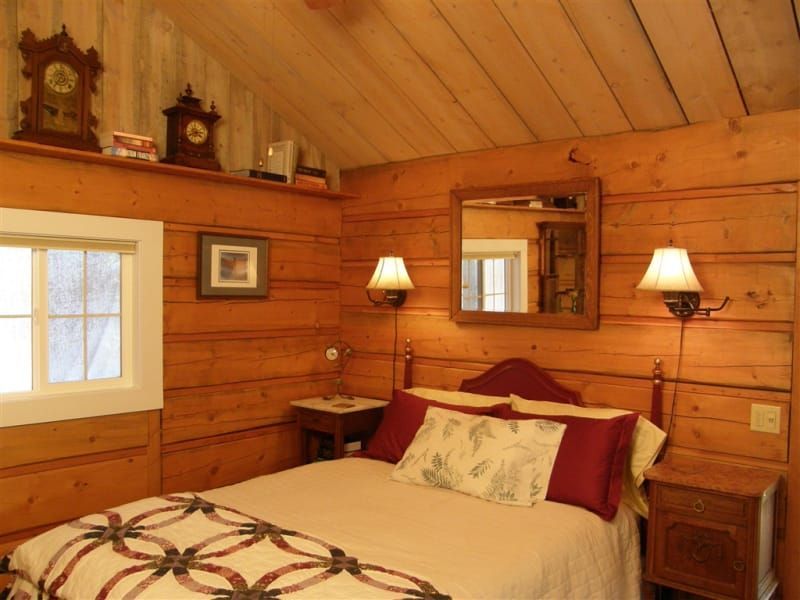 A bedroom with a bed and a mirror on the wall