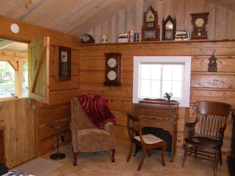 A living room in a log cabin with clocks on the wall