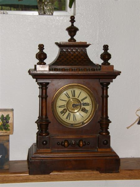 A wooden clock with roman numerals on the face