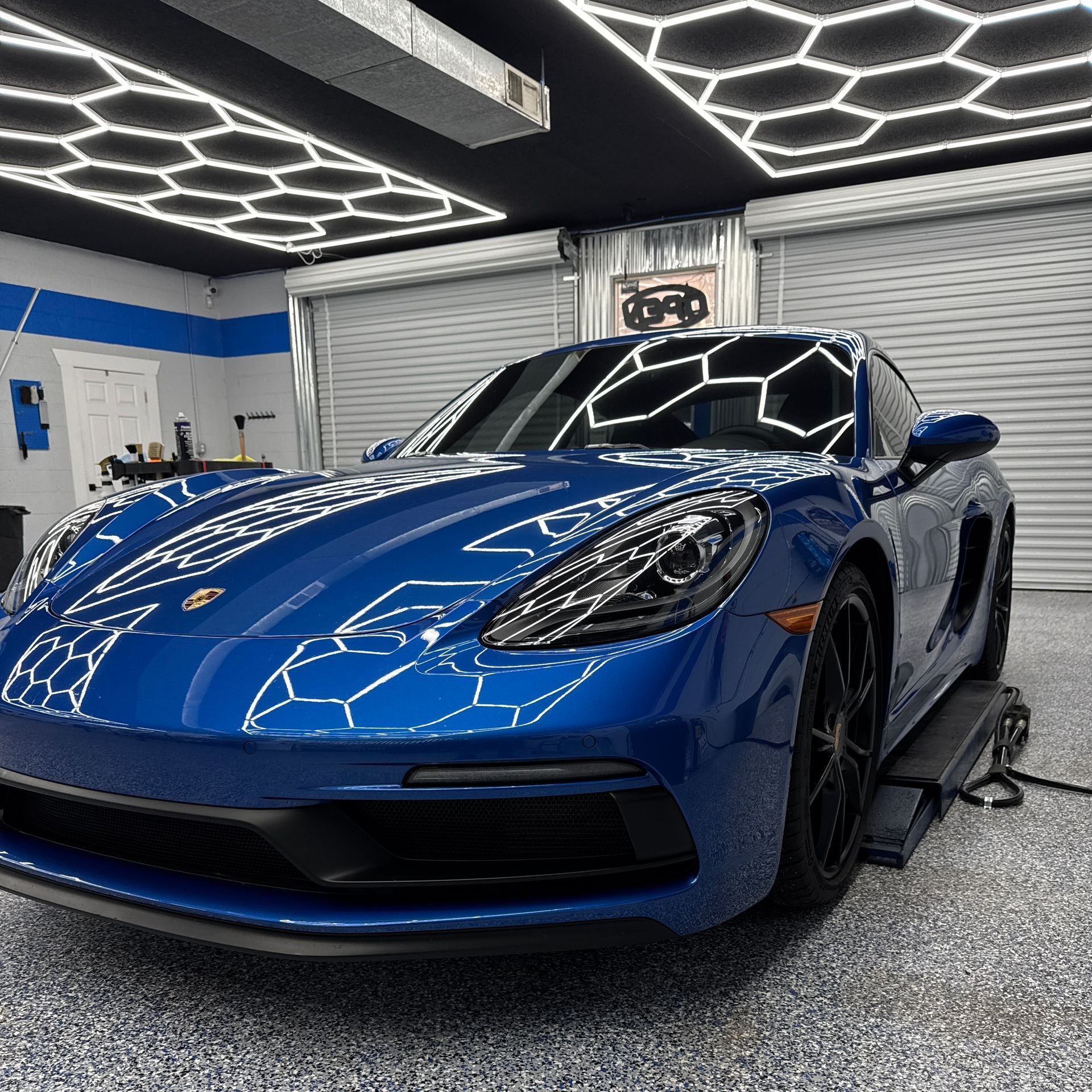 A black truck is parked in a garage next to a wall.