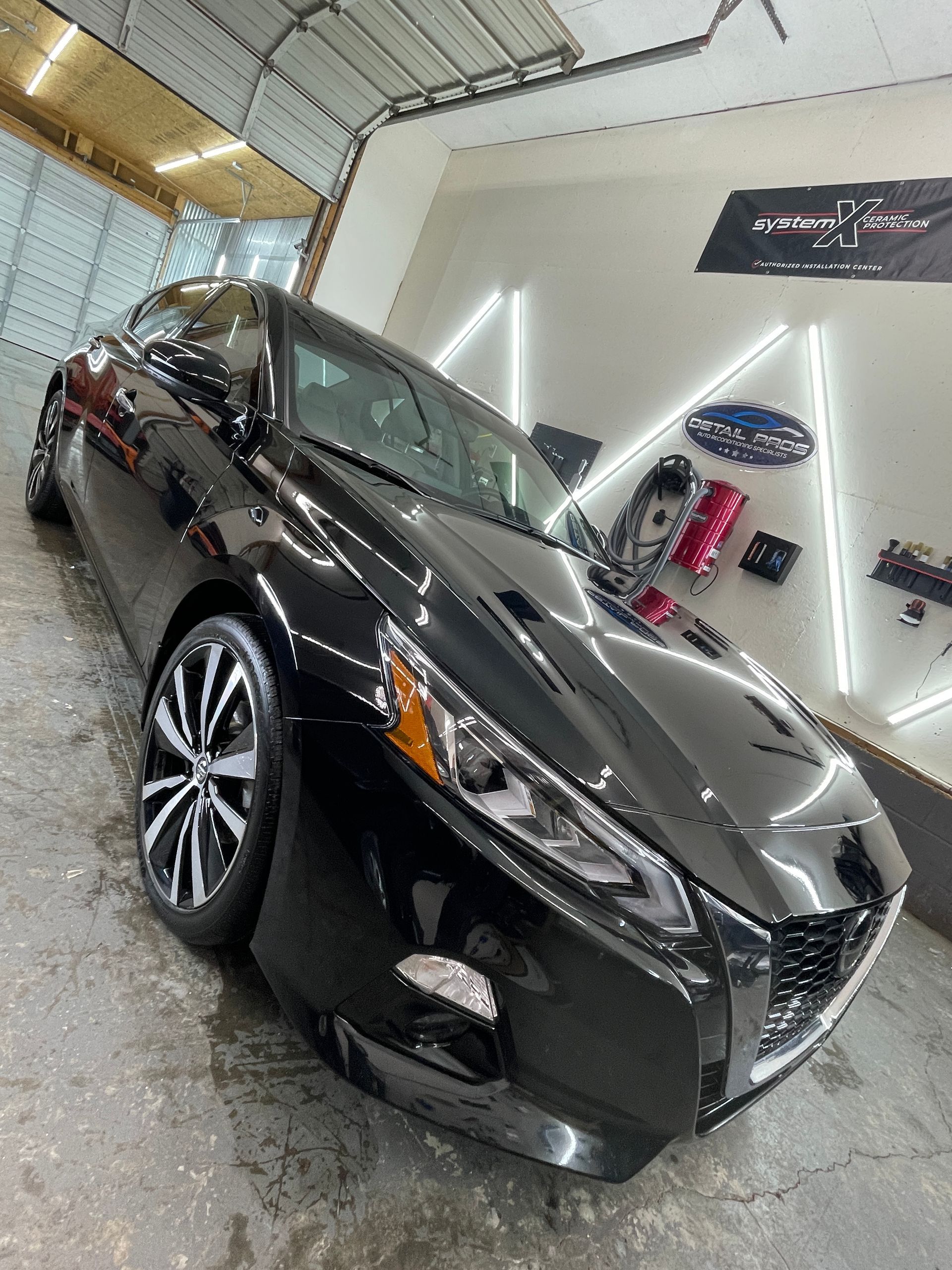 A black car is parked in a garage.