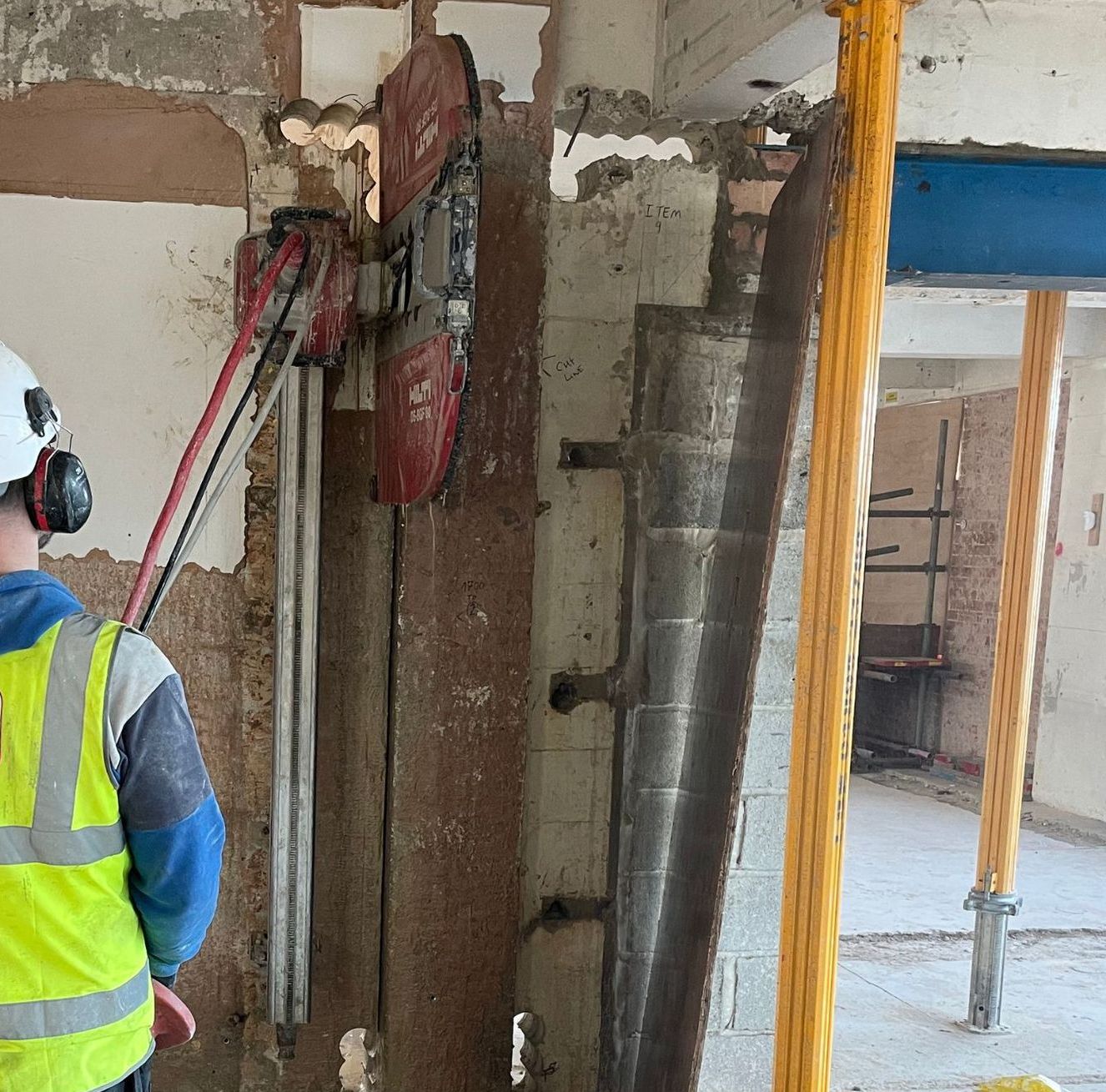 A man wearing a yellow vest that says mhoi on it