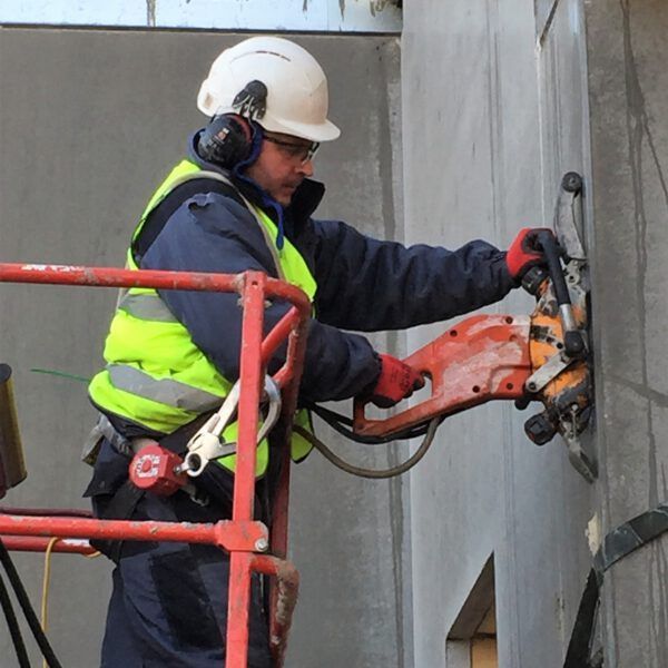 A man wearing a yellow vest that says mhoi on it