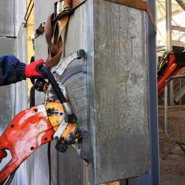 A person is using a circular saw to cut a wall
