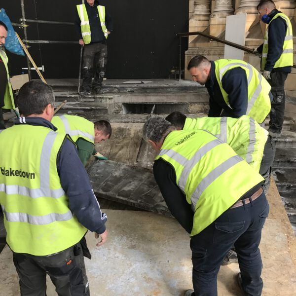 A group of men wearing yellow vests that say maketown