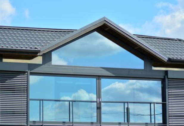 Modern building with triangular window above large glass panels.